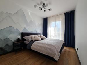 een slaapkamer met een bed met een muurschildering van de bergen bij Komfortowy Apartament Pod Lasem Villa Fonte 21 Polanica Zdrój in Polanica-Zdrój