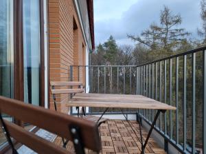 a balcony with two benches and a wooden table at Komfortowy Apartament Pod Lasem Villa Fonte 21 Polanica Zdrój in Polanica-Zdrój