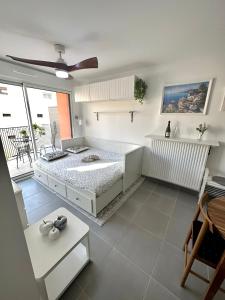 une chambre blanche avec un lit et un balcon dans l'établissement Charmant Studio à proximité du Port de Nice, à Nice