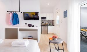 a white kitchen with a table and a counter at Sunwaves Beach studio I in Ialyssos