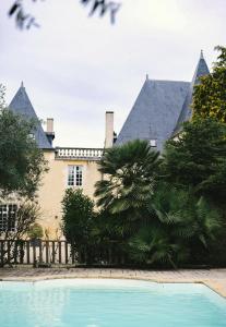 a house with a swimming pool in front of it at Château de La Vallade in Saint-Porchaire