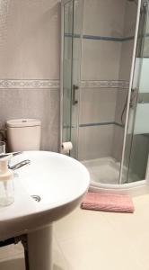 een witte badkamer met een wastafel en een douche bij Apartamento Dhanvantari en Adeje Paradise in Playa Paraiso