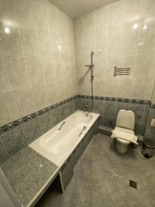 a bathroom with a bath tub and a toilet at Piccolo Casa Bella Hotel in Tbilisi City