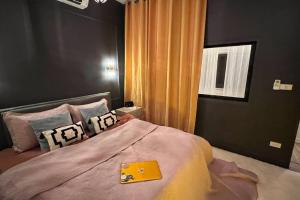 ein Schlafzimmer mit einem Bett mit einem gelben Ordner darauf in der Unterkunft Spacious fancy house/centrally located in Hinkong