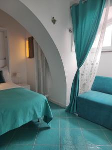 een slaapkamer met een bed, een raam en een bank bij Amalfi Small Wonder Tiny Town House in Amalfi