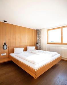 a bedroom with a large white bed in a room at Hotel Gasthof Wälderhof in Lingenau