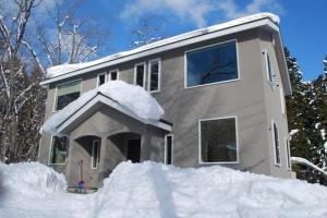a house with a pile of snow in front of it at Cat's Villa Hakuba 3- Vacation STAY 82216 in Hakuba
