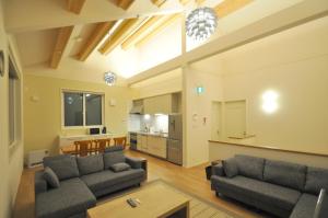 a living room with two couches and a kitchen at Cat's Villa Hakuba 3- Vacation STAY 82216 in Hakuba