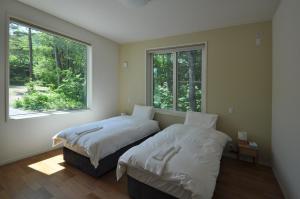 2 Betten in einem Zimmer mit Fenster in der Unterkunft Cat's Villa Hakuba 4- Vacation STAY 82229 in Hakuba