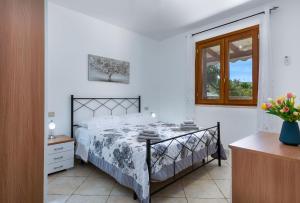 a bedroom with a bed and a window at Bedda Luna Villa in San Vito lo Capo