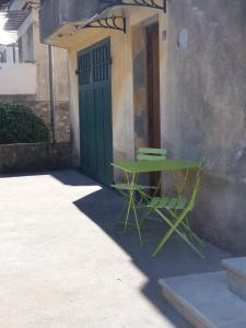 una mesa verde y una silla frente a un edificio en Charmant T3 Les Clés de Digne, jardin, rez de chaussée, en Digne-les-Bains