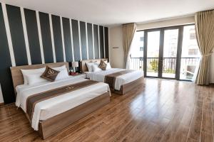 um quarto de hotel com duas camas e uma grande janela em The One Hotel em Hai Phong