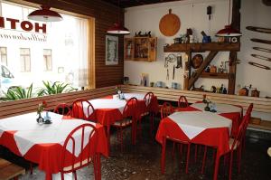 a restaurant with red and white tables and chairs at Pension Hotel Turmblick in Auerbach