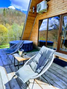 a deck with chairs and a table and a tv on a cabin at Casuta dintre nuci 
