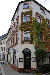 a building with ivy growing on it on a street at Hotel Hardys-Eck in Auerbach