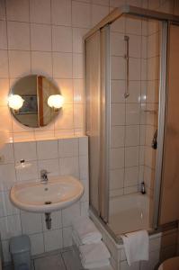 La salle de bains est pourvue d'un lavabo, d'une douche et d'une baignoire. dans l'établissement Hotel Hardys-Eck, à Auerbach