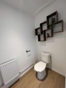 une salle de bains blanche avec toilettes et radiateur dans l'établissement La Valencianne, à Valenciennes