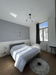 - une chambre blanche avec un lit et une fenêtre dans l'établissement La Valencianne, à Valenciennes