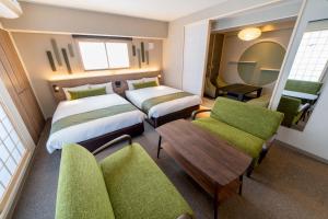 a hotel room with two beds and a table and chairs at RESI STAY Hotel SUN CHLORELLA in Kyoto