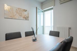 een conferentieruimte met een houten tafel en stoelen bij Home Abate Gimma 170 in Bari