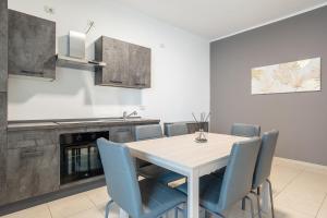 a kitchen with a dining room table and blue chairs at Home Abate Gimma 170 in Bari