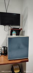una televisione sopra una scrivania di DUCK INN AND RESTAURANT a Manila