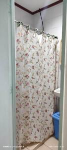 a shower curtain with flowers on it in a bathroom at DUCK INN AND RESTAURANT in Manila