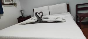 uma cama com dois cisnes feitos de toalhas em DUCK INN AND RESTAURANT em Manilla