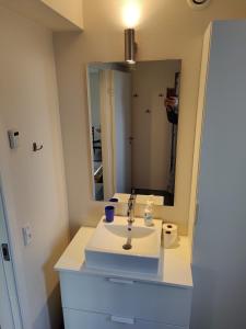 a bathroom with a white sink and a mirror at Villa-Amby in Ringkøbing