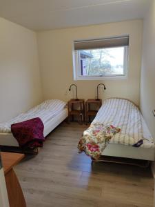 two beds in a room with a window at Villa-Amby in Ringkøbing