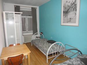 a small room with a bed and a table and chairs at Logies Lucullus in Blankenberge