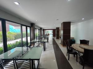 a restaurant with tables and chairs and large windows at Bordin Hotel in Ubon Ratchathani