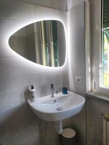een witte wastafel in een badkamer met een spiegel bij AllogGio' in Calice Ligure
