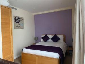 a bedroom with a bed with blue pillows at Liberty Wharf Apartments in Saint Helier Jersey +25 photos