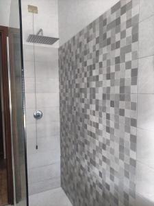 een badkamer met een douche en een betegelde muur bij AllogGio' in Calice Ligure