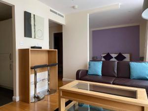 een woonkamer met een bank en een tafel bij Liberty Wharf Apartments in Saint Helier Jersey