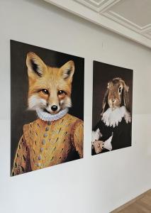deux peintures d'un renard et d'un lapin sur un mur dans l'établissement Hotel Fuchs & Hase SELF CHECK IN, à Rosegg