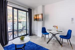 a living room with a table and chairs and a large window at SEASALT Apartments Rafailovichi in Budva