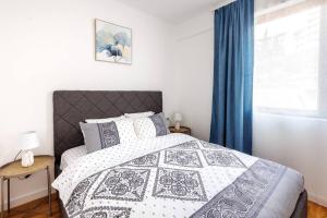 a bedroom with a black and white bed and a window at SEASALT Apartments Rafailovichi in Budva