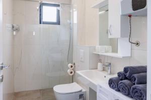 a bathroom with a shower and a toilet and a sink at SEASALT Apartments Rafailovichi in Budva