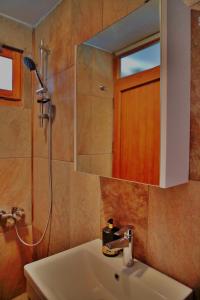 ein Bad mit einem Waschbecken, einer Dusche und einem Spiegel in der Unterkunft The Mira House in Ayvalık