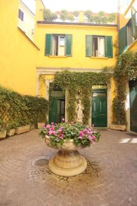 un edificio amarillo con puertas verdes y un jarrón de flores en IMHOME - Cadorna House, en Milán