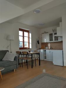 a living room with a couch and a table and a kitchen at Apartment Felicitas in Kašperské Hory