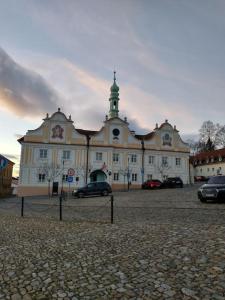 a large building with cars parked in front of it at Apartment Felicitas in Kašperské Hory