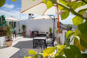 a patio with tables and chairs and an umbrella at Vitium C&oacute;rdoba in C&oacute;rdoba