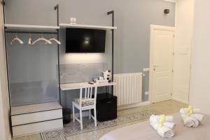 - une chambre avec un lit et une télévision murale dans l'établissement Casa Granatelli, à Palerme