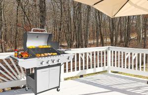 a grill on a deck with a table with fruit on it at Stunning Poconos Villa- Hot Tub, Pool, Game Room, BBQ & more in East Stroudsburg