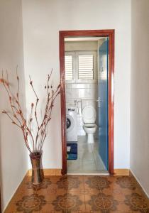 a bathroom with a toilet and a vase with a plant at Apartman Krivokapic in Igalo