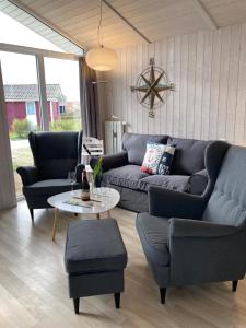 sala de estar con sofá, sillas y mesa en Bootshus - Strandpark 15 en Grömitz