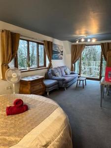 a bedroom with a large bed and a couch at Barnfields Retreat in Little Clacton